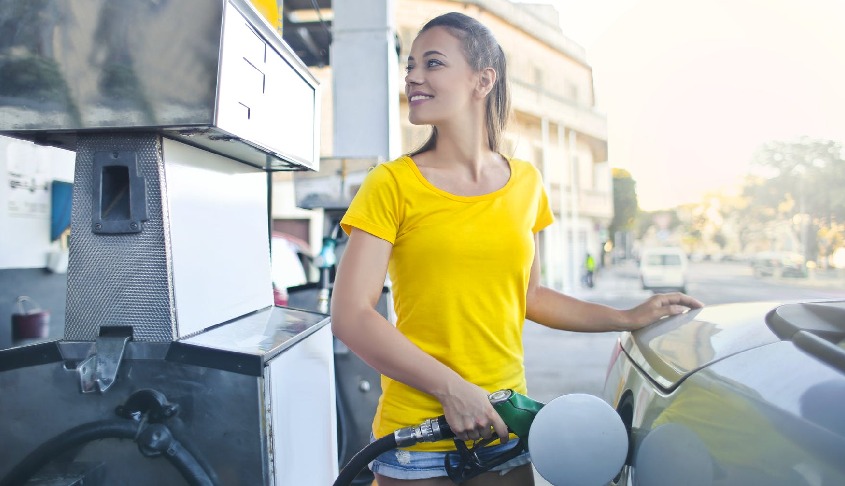 mujer respostando combustible en gasolinera