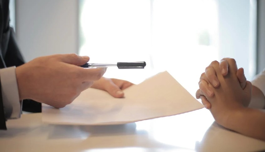 manos de dos personas para firmar con boligrafo y papel